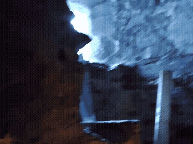 A dark vaulted room showing a barrel and a candle. 