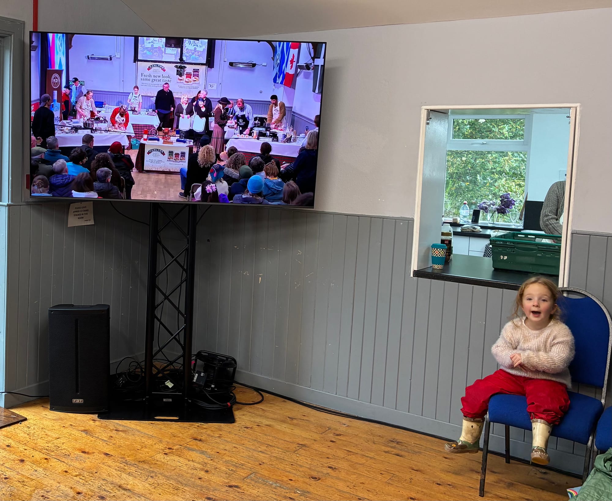 Lily sitting on a chair next to a screen showing the championship.