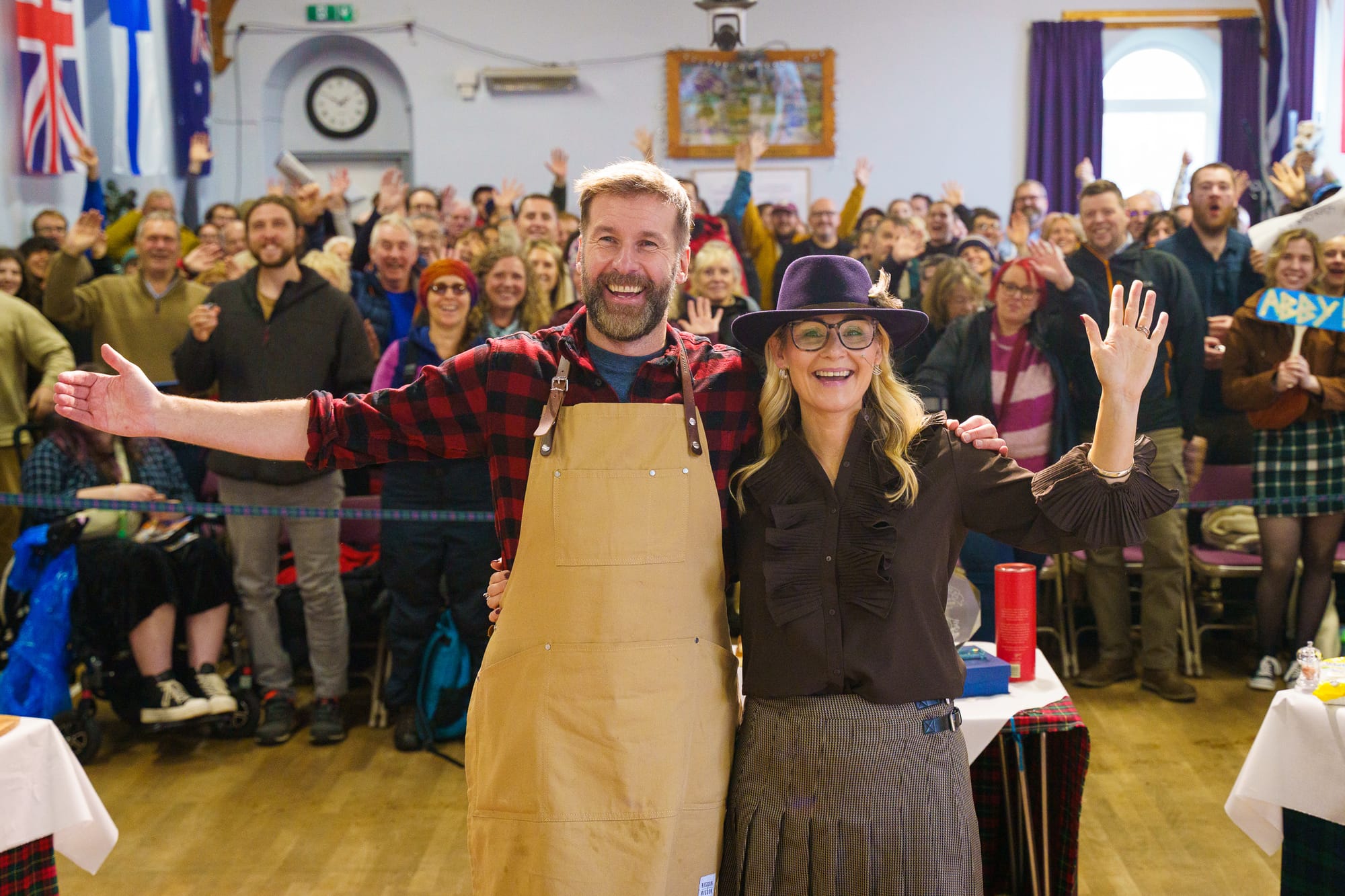 Coinneach Macleod and Sarah Rankin smile in the foreground with happy spectators behind them.