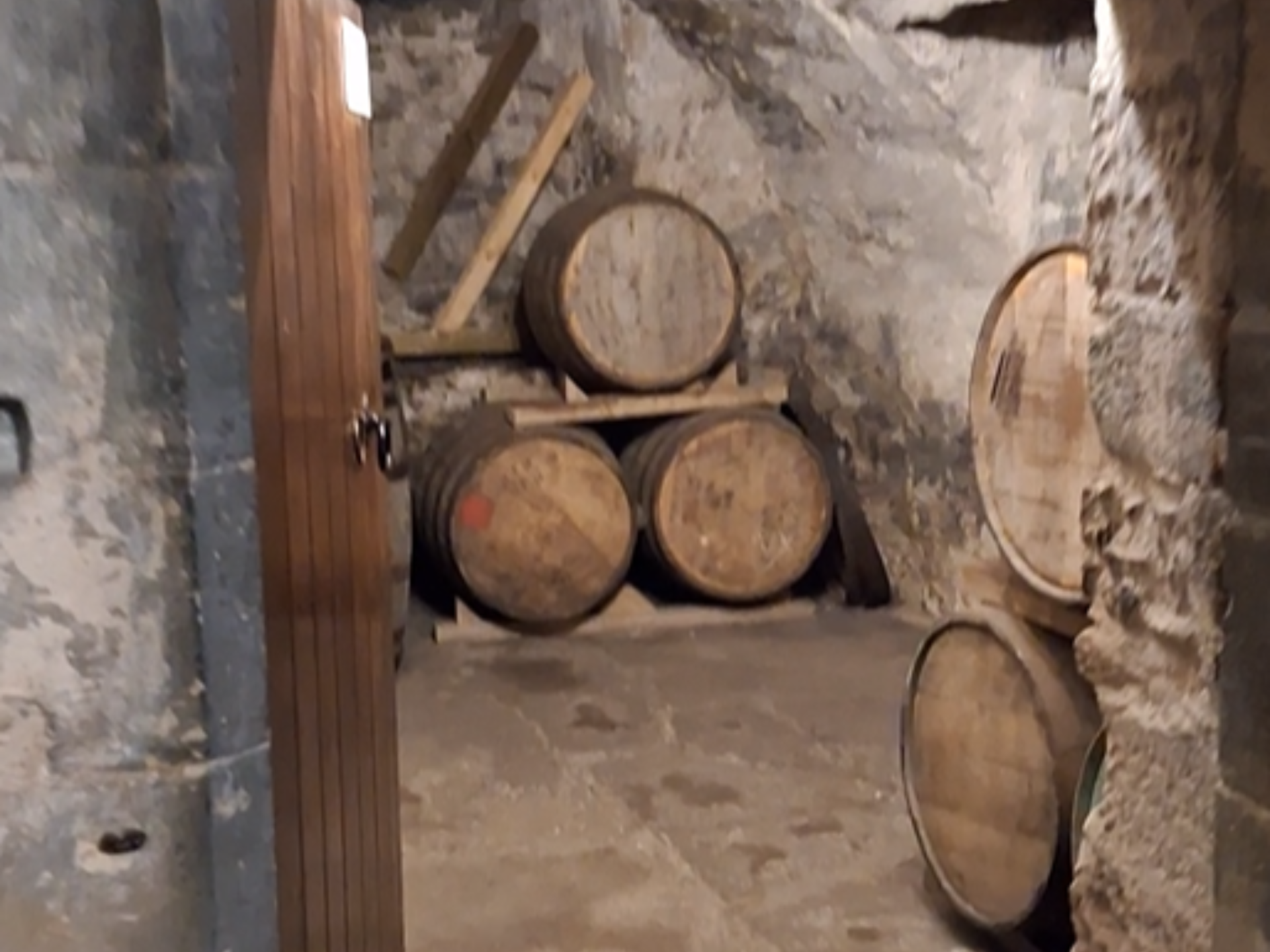A stack of barrels in an old, stone, vaulted room in the castle.