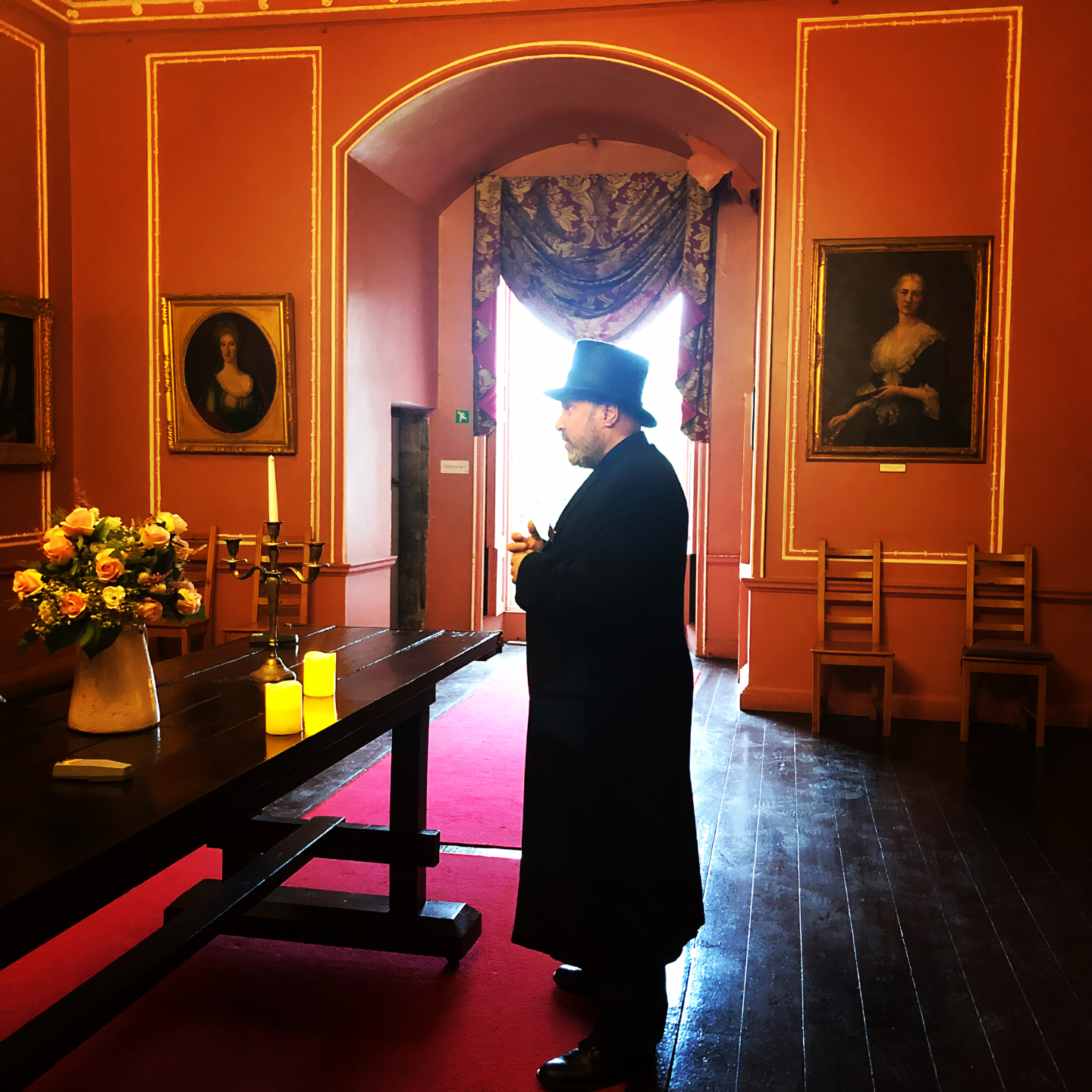 Gary, dressed all in black, stands in the castle's Pink Room. 