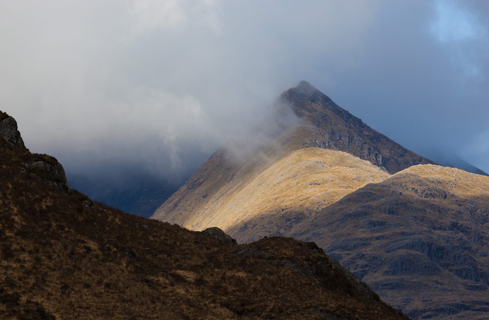 The peak of Stob A’ Chearcaill amid low cloud.
