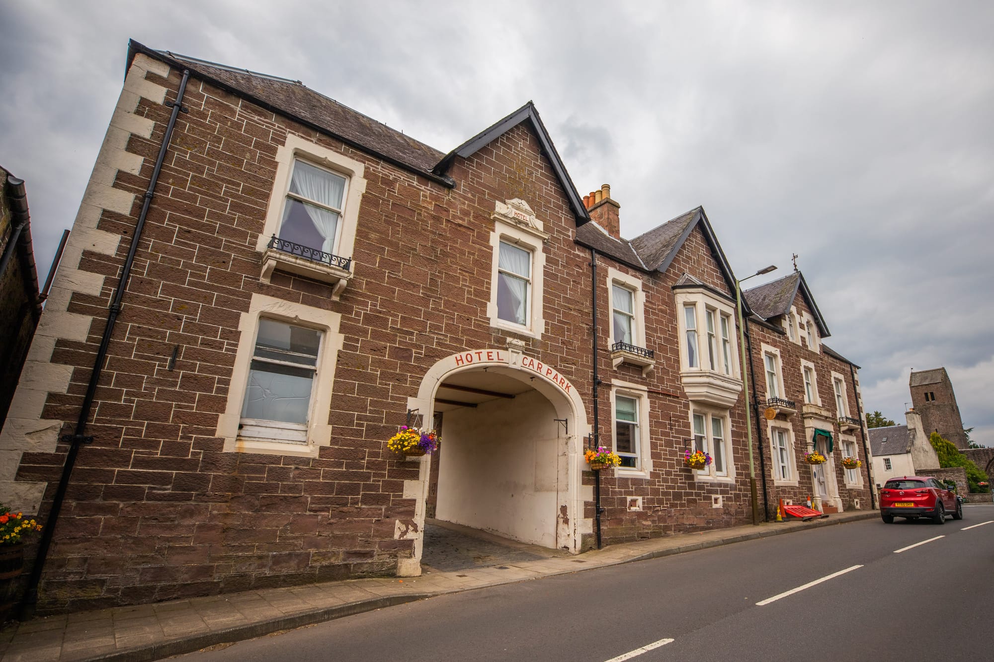 The exterior of Coorie Inn from the street. It is an old stone building with cream painted window surrounds.