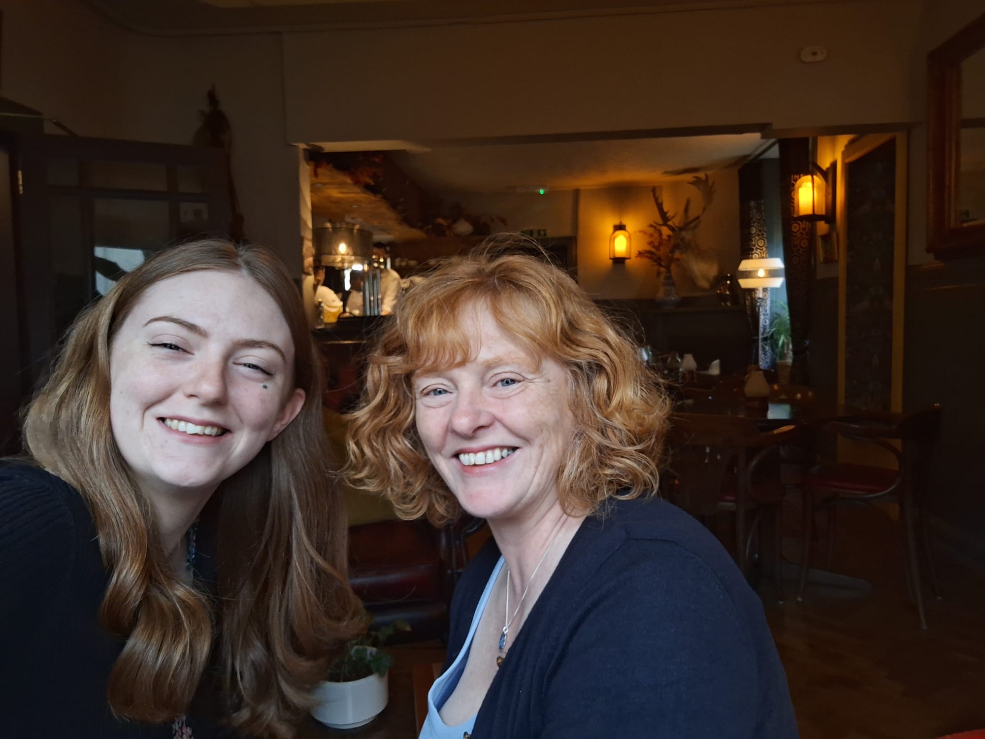 Beth and her mum smiling with the bar behind them.