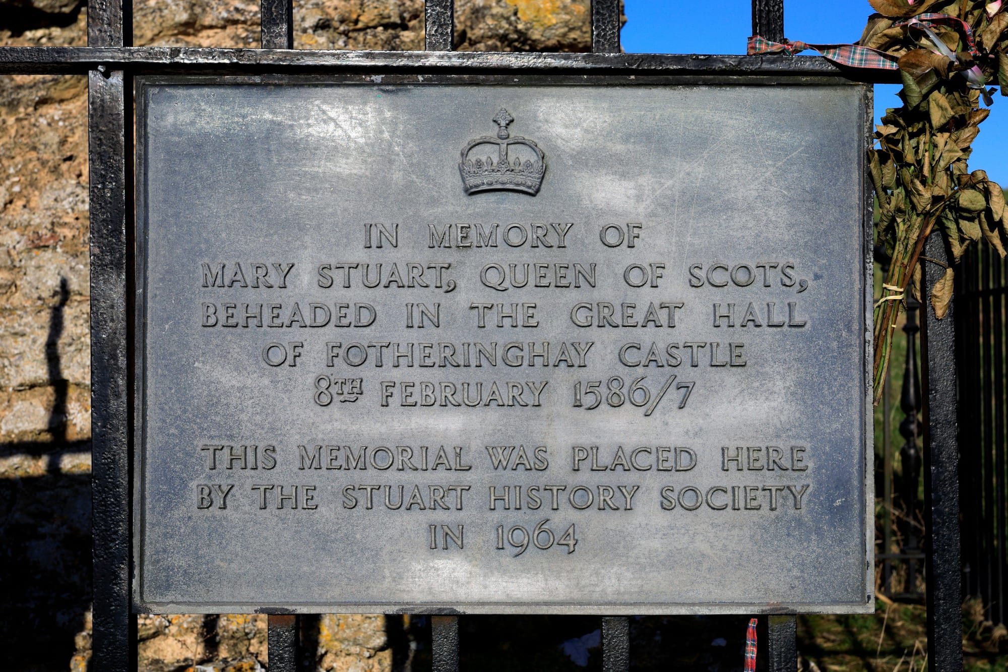 A plaque to Mary outside what once was Fotheringhay Castle, of which only rubble remains, reading "In memory of Mary Stuart, Queen of Scots, beheaded in the great hall of Fotheringhay Castle February 8, 1586/7.