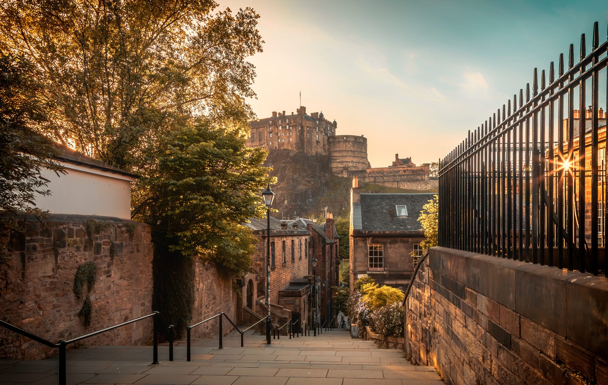A sunset view of a vennel in Edinburgh with the castle in the background.
