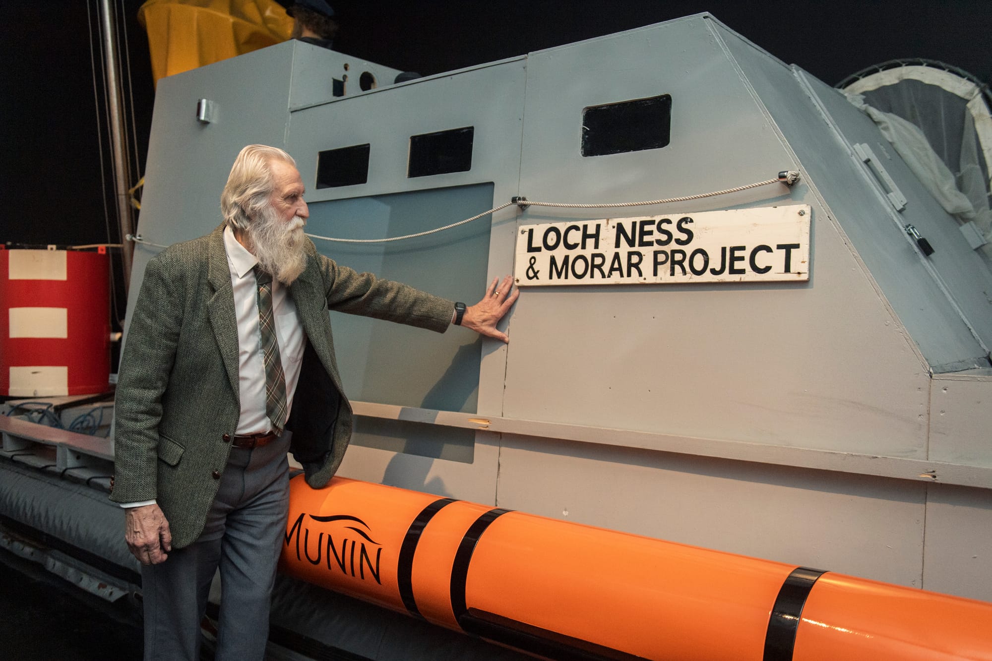 Adrian Shine next to a sign for the Loch Ness and Morar project.