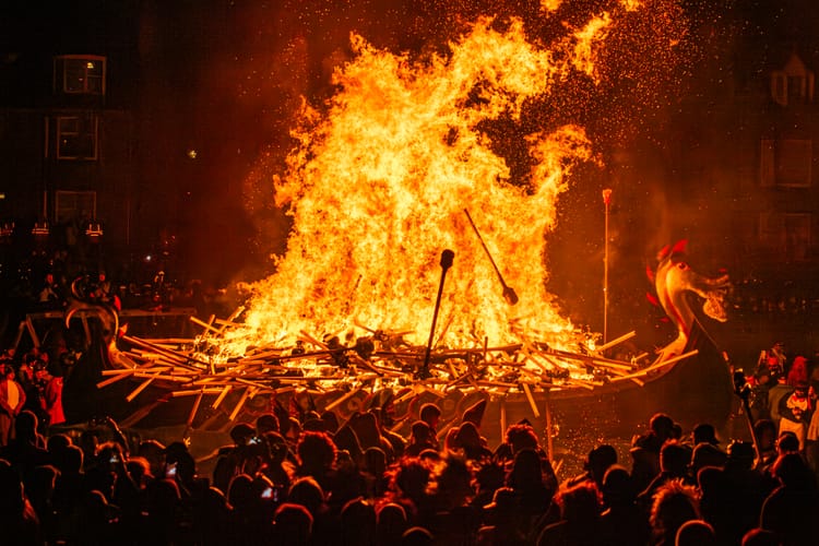 The galley boat set on fire at Up Helly Aa, with crowds surrounding it.