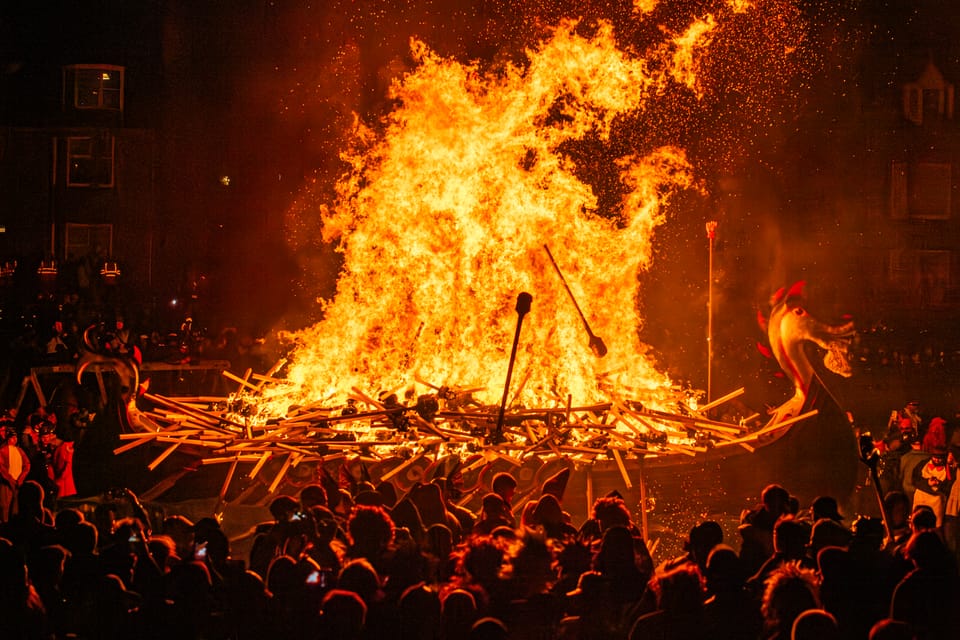 The galley boat set on fire at Up Helly Aa, with crowds surrounding it.